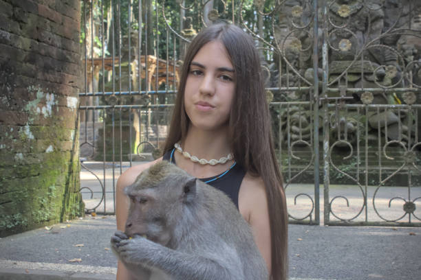 istock Adorable girl with macaque monkey 2176353829