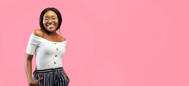istock Afro Woman Smiling Standing With Hands In Pockets, Yellow Background 2176355584