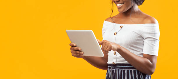 istock Unrecognizable Afro Girl Using Tablet Over Orange Background, Cropped, Panorama 2176355707