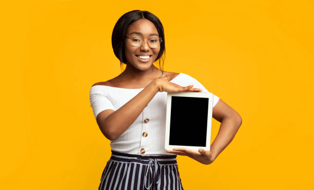 istock Black Girl Showing Tablet Blank Screen Over Orange Background, Mockup 2176355723