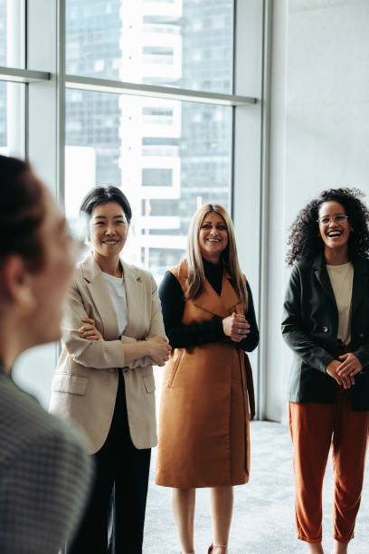 Women supporting each other during a business conference meeting in a modern office, showcasing teamwork and collaboration.