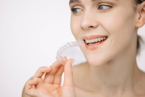 istock A woman uses an orthodontic silicone trainer for teeth correction. This mobile device highlights modern dental care methods and whitening systems, promoting a healthy and radiant smile. 2176361338
