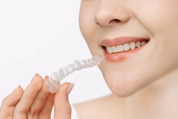 istock A woman uses an orthodontic silicone trainer for teeth correction. This mobile device highlights modern dental care methods and whitening systems, promoting a healthy and radiant smile. 2176361406