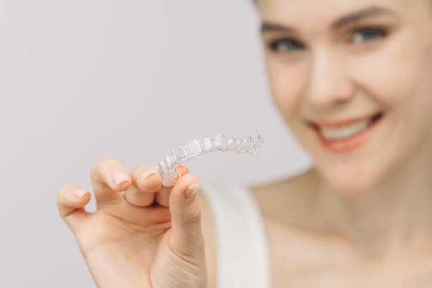 istock A woman uses an orthodontic silicone trainer for teeth correction. This mobile device highlights modern dental care methods and whitening systems, promoting a healthy and radiant smile. 2176361477
