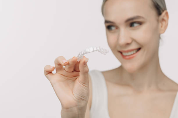 istock A woman uses an orthodontic silicone trainer for teeth correction. This mobile device highlights modern dental care methods and whitening systems, promoting a healthy and radiant smile. 2176361481