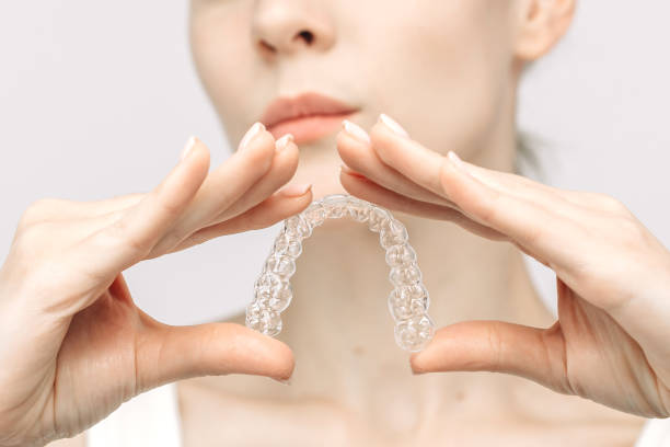 istock A woman uses an orthodontic silicone trainer for teeth correction. This mobile device highlights modern dental care methods and whitening systems, promoting a healthy and radiant smile. 2176361546