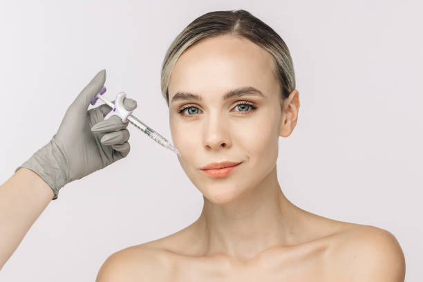 istock A woman confidently poses against a white background beside a syringe. This image captures the essence of cosmetic services, highlighting the importance of self-care and skin health. 2176361827