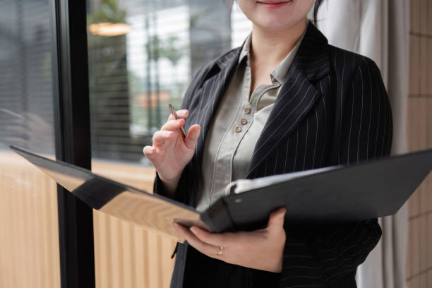 istock Confident Businesswoman Reviewing Documents in Modern Office Setting with Natural Light and Professional Attire 2176362767
