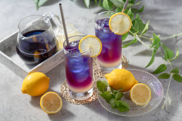 istock Lemonade with blue and violet butterfly pea flower tea on light gray background with copy space 2176363183