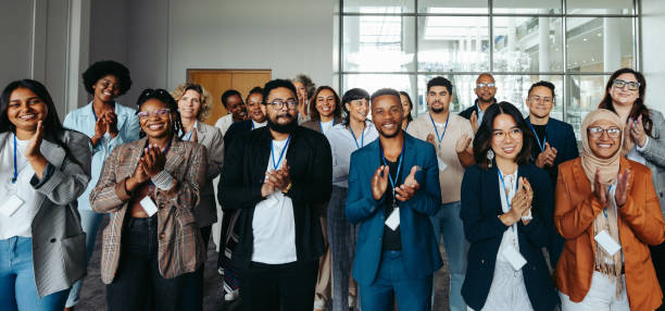 Diverse business seminar audience clapping from first person view perspective