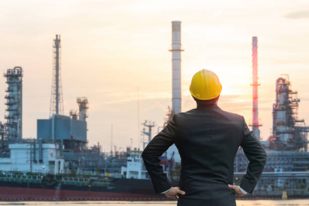 istock Engineer overseeing oil refinery at sunset 2176364417