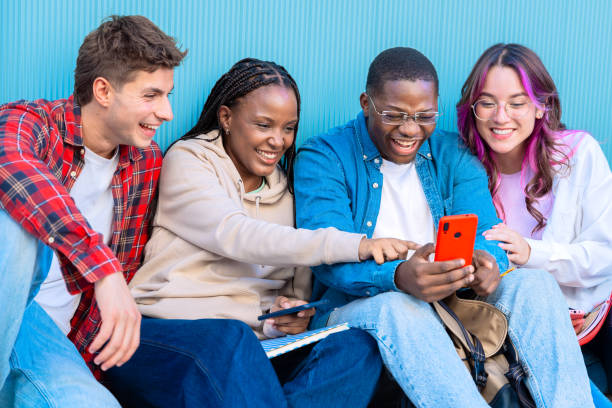 istock Diverse young people sitting outdoors using smartphones 2176370906