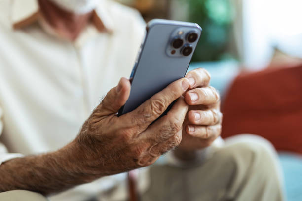 istock Senior man, phone and typing on sofa for web surfing with retirement, chess game and connection in home. Elderly person, mobile and relax with ebook app, online puzzle and internet scroll in lounge. 2176373490
