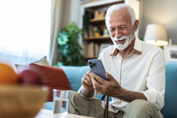 istock Senior man, phone and typing on sofa for web surfing with retirement, chess game and connection in home. Elderly person, mobile and relax with ebook app, online puzzle and internet scroll in lounge. 2176373631
