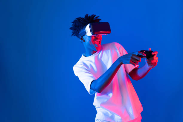 istock American African player wearing VR joystick neon lighting wall. Contrivance. 2176374532
