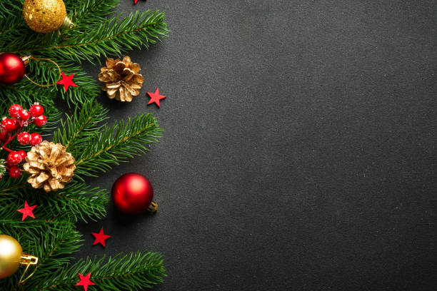 istock Black Christmas background with fir tree and holiday decorations. 2176374712