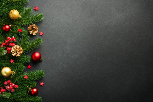 istock Black Christmas background with fir tree and holiday decorations. 2176374760