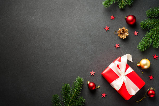 istock Black Christmas flat lay background with present, fir tree and holiday decorations. 2176374781