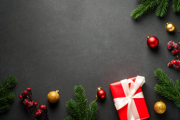 istock Black Christmas flat lay background with present, fir tree and holiday decorations. 2176374817