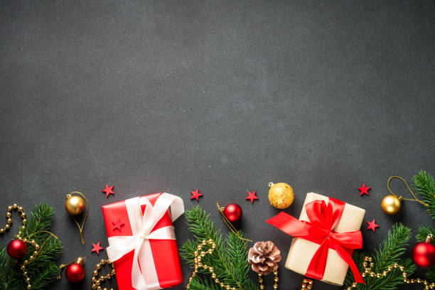 istock Black Christmas flat lay background with present, fir tree and holiday decorations. 2176374919