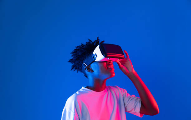 istock Surprised African looking VR holding object hologram neon wall. Contrivance. 2176375563