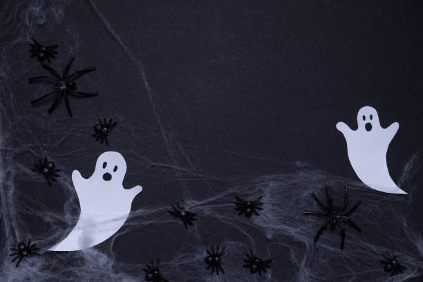 istock Ghosts shrouded in spider webs with spiders on black background. Halloween holiday. For backgrounds and presentations 2176376294