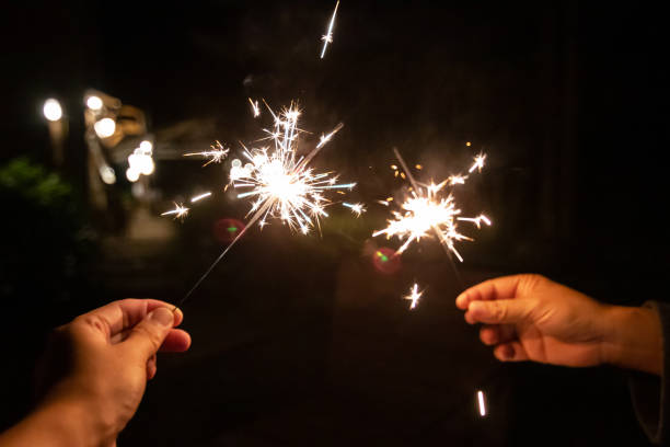 istock Two hands holding sparklers in the night, creating a festive atmosphere filled with light and celebration. 2176377549