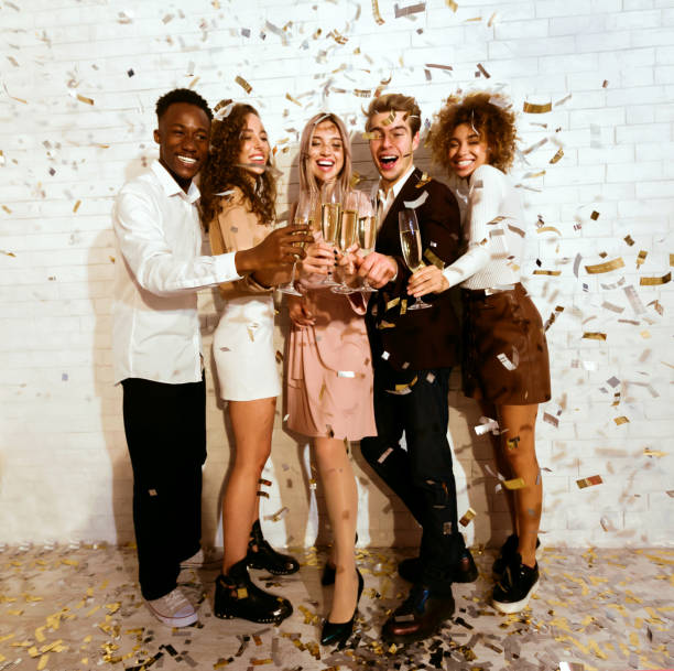 istock Friends Celebrating Drinking Champagne Standing Under Falling Confetti Indoors 2176381597