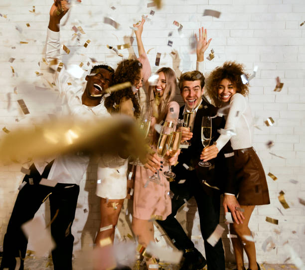 istock Happy young people celebrating drinking champagne showered with confetti indoor 2176381615