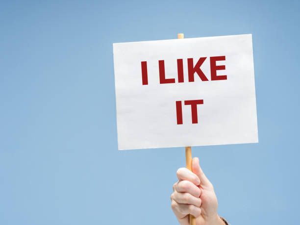 istock A hand holding a placard with the phrase I LIKE IT against light blue background 2176381768