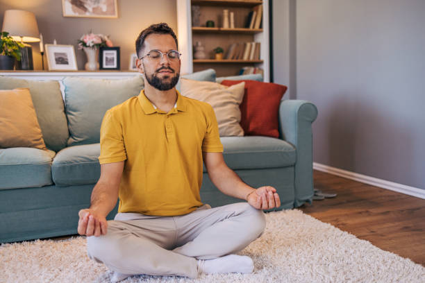 istock A mid adult  man practices yoga at home 2176382497