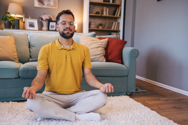 istock A mid adult  man practices yoga at home 2176383393