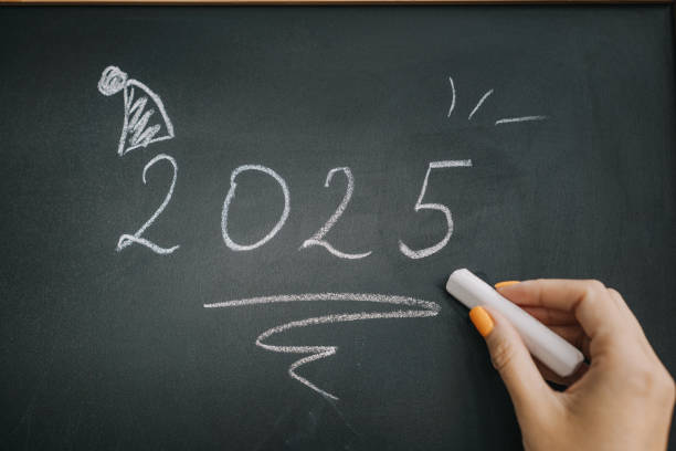 istock Writing the year 2025 on a chalkboard with a festive decoration in the corner 2176387241