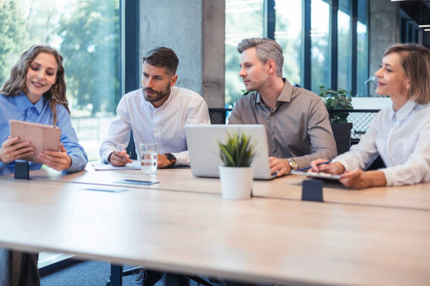 istock Happy four business people executive team working at laptop having discussion at office meeting showing financial project 2176388385