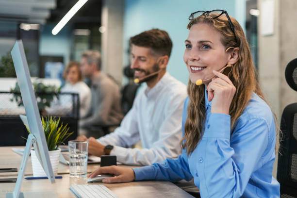 istock Portrait of call center worker accompanied by her team. Smiling customer support operator at work. 2176389679