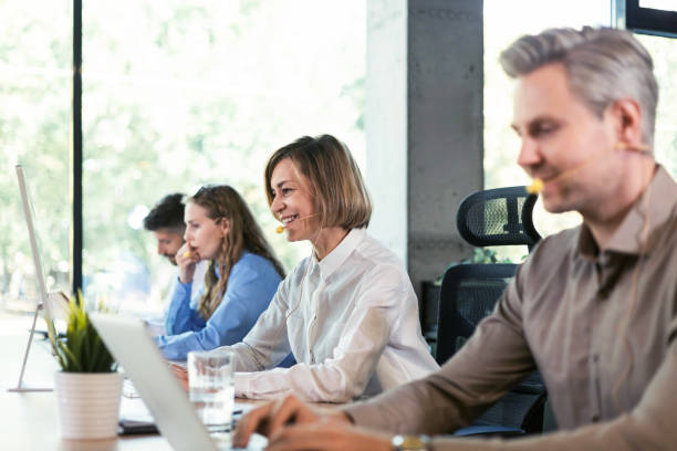 istock Portrait of call center worker accompanied by her team. Smiling customer support operator at work. 2176389801