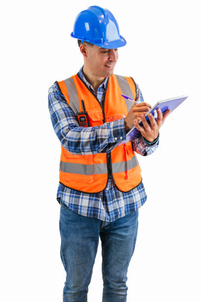 istock vertical Construction worker writing in a notebook with a pen wearing orange vest and safety helmet 2176391559