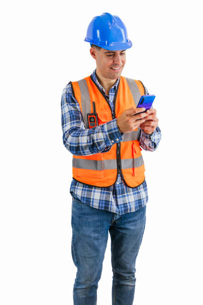 istock vertical Smiling construction worker texting on his smartphone wearing orange vest and safety helmet 2176391653