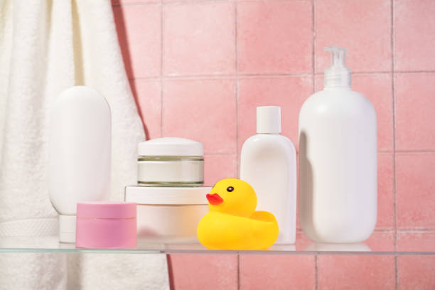 Bathroom with Cosmetic products at glass shelf at pink background.