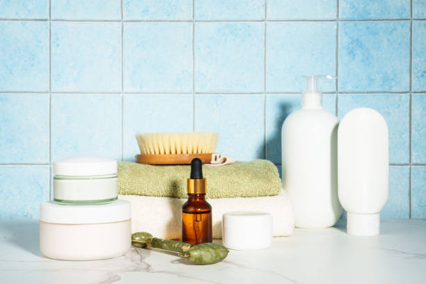 Face cream, serum bottle, shapmoo and stack of towels.
