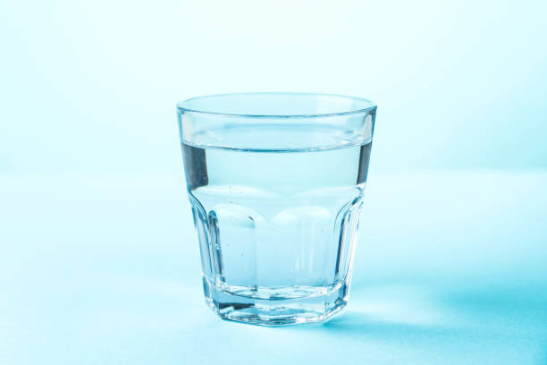 istock Glass of water on blue background. 2176392343
