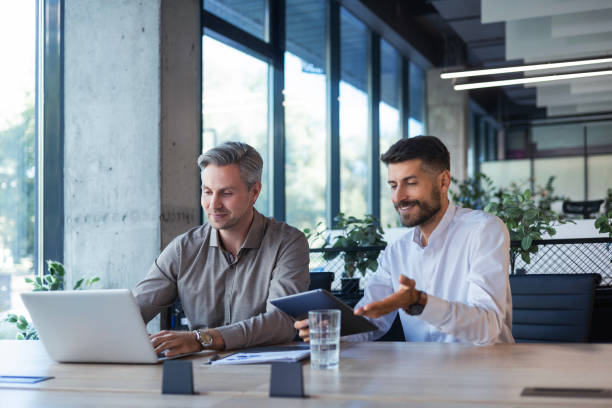 istock Two business men talking to each other discussing their business proposal. 2176394701