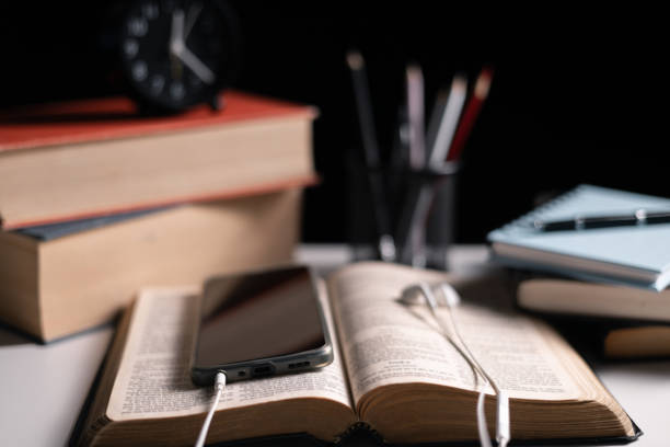 istock Old library, an open Bible lay on the table, its holy pages of scripture illuminated in the dark room. bible, holy, dark, old, open, library, pages, scripture, table, book, page. 2176394818