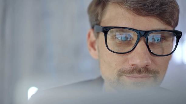 istock Businessman with glasses looking intently obscured partially by a translucent surface of laptop. Business concept 2176395400