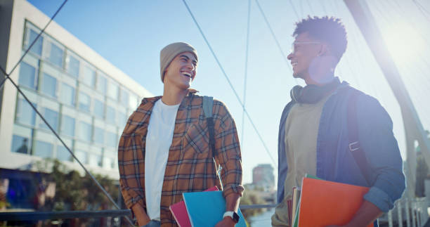 istock Student, laughing and friends with people and books for learning, future and knowledge. University, academy and youth development with men talking at college campus for scholarship, funny and study 2176396447
