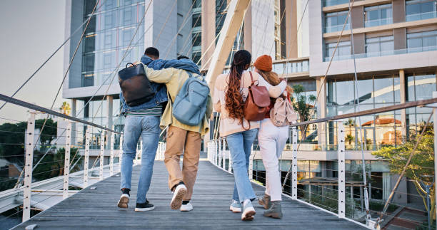 istock Back, college and friends with people and walking for education, learning and knowledge. University, academy and youth development with students on campus for scholarship, school and studying 2176396573