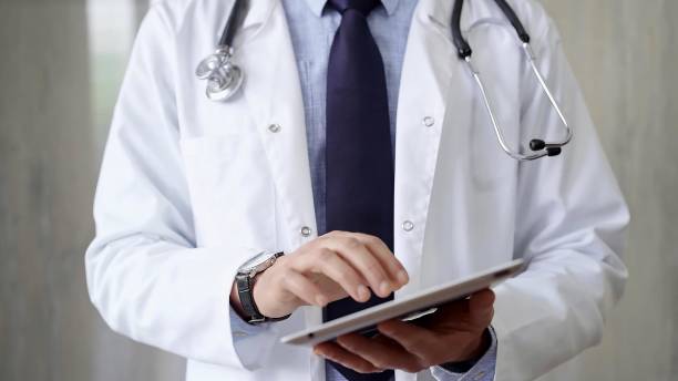 istock Doctor man wearing lab coat and stethoscope using tablet computer in hospital. Medicine and science 2176398083