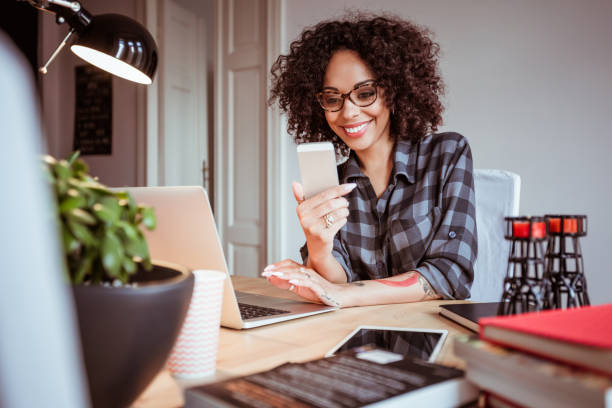 istock Beautiful young woman at office using mobile phone 2176398304