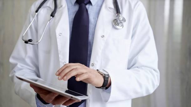 istock Doctor man wearing lab coat and stethoscope using tablet computer in hospital. Medicine and science 2176398318