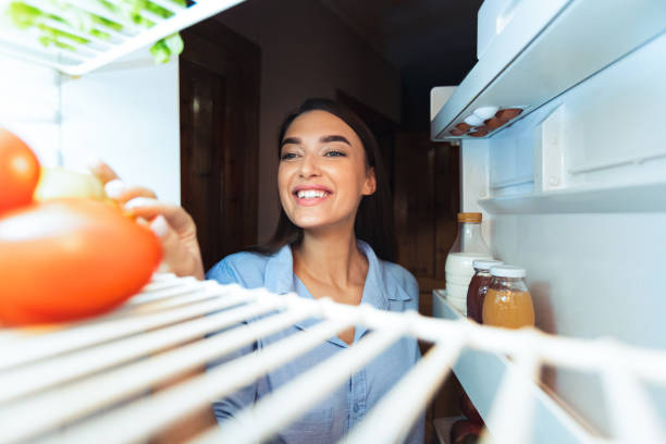 istock Young girl opening her fridge at home, view from inside 2176399843